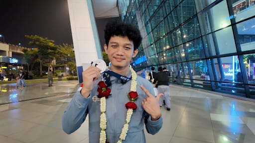 Muhammad Rafi Qsan memegang medali perak IEO 2026 setibanya di bandara